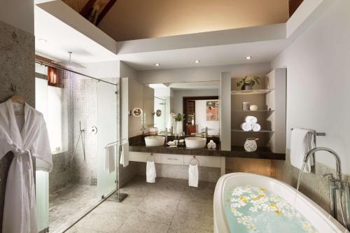 Hilton Moorea Lagoon Resort & Spa في بابيتوييْ: حمام به مغسلتين وحوض استحمام