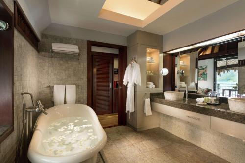 a bathroom with a tub and a sink at Hilton Moorea Lagoon Resort & Spa in Papetoai