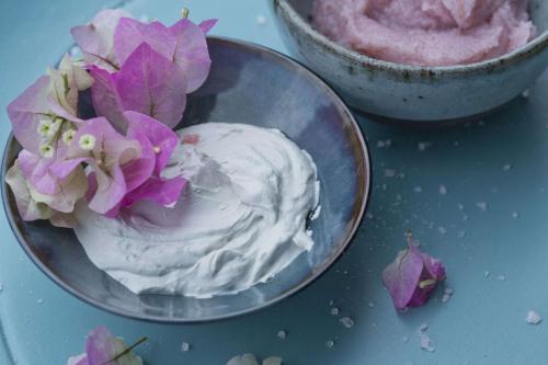 a bowl of whipped cream with purple flowers in it at Hilton Moorea Lagoon Resort & Spa in Papetoai