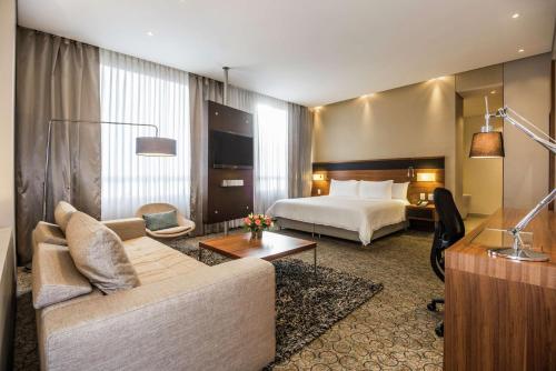 Habitación de hotel con cama y sofá en DoubleTree by Hilton Bogota Parque 93, en Bogotá