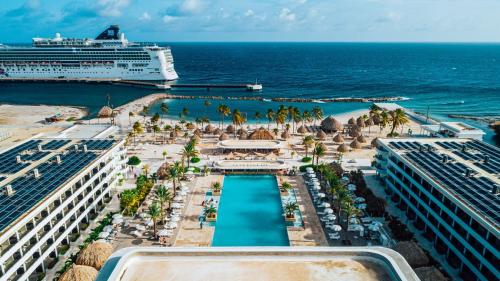 eine Luftansicht auf den Strand und ein Kreuzfahrtschiff in der Unterkunft Mangrove Beach Corendon Curacao All-Inclusive Resort, Curio in Willemstad