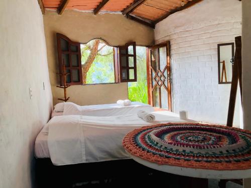 - une chambre avec un lit dans une pièce dotée d'une fenêtre dans l'établissement Espaço Shanti - Chalés, à Sao Jorge