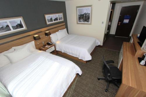 a hotel room with two beds and a desk at Hampton Inn by Hilton Leon in León