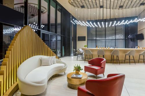 a lobby with a white couch and chairs and a bar at Hilton San Jose La Sabana in San José