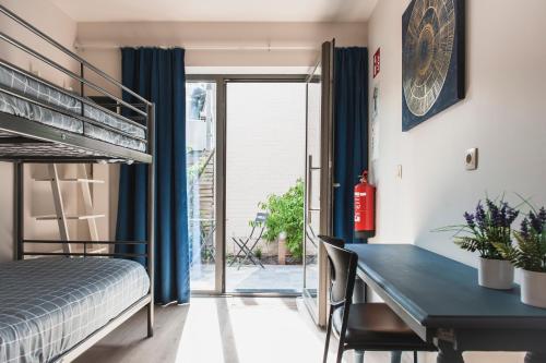 1 dormitorio con cama, escritorio y litera en Het Oplaadpunt bed, bike, hike, 4-8 p, en Dixmuda