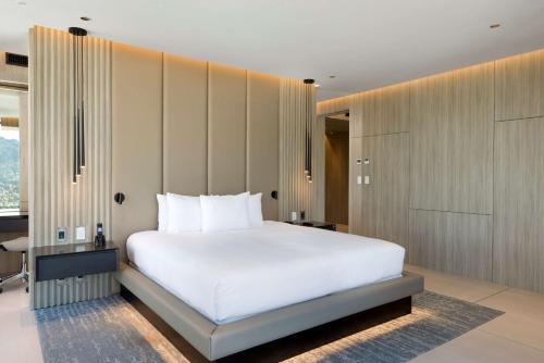 a bedroom with a large white bed and a window at Hilton San Jose La Sabana in San José