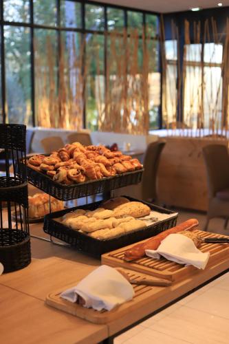 Una mesa cubierta con bandejas de pan y pasteles. en Château de La Dame Blanche - Logis, en Geneuille