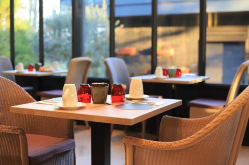 una mesa en un restaurante con mesas y sillas en Château de La Dame Blanche - Logis, en Geneuille
