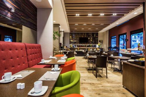a restaurant with tables and chairs and a bar at Embassy Suites by Hilton Bogotá - Rosales in Bogotá