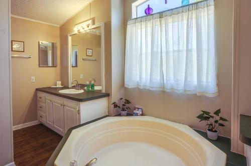 ein Badezimmer mit einer großen Badewanne und einem Waschbecken in der Unterkunft Secluded Rural Home in Normangee! 