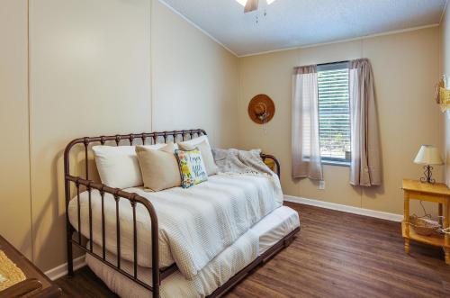 Schlafzimmer mit einem Bett mit weißer Bettwäsche und einem Fenster in der Unterkunft Secluded Rural Home in Normangee! 