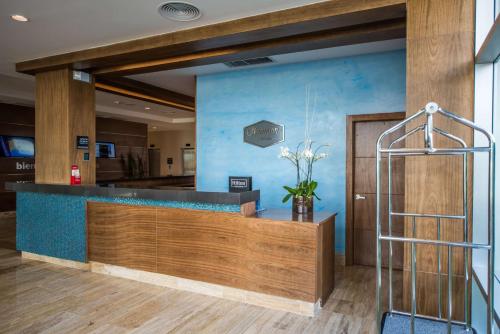a lobby with a blue wall and a reception desk at Hampton By Hilton Santo Domingo Airport in Boca Chica