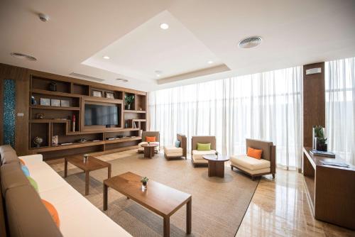 a living room with a couch and chairs and a tv at Hampton By Hilton Santo Domingo Airport in Boca Chica