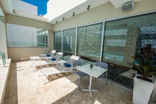 an empty room with chairs and tables and windows at Hampton By Hilton Santo Domingo Airport in Boca Chica