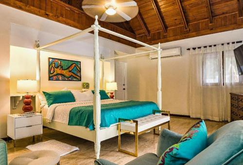 ein Schlafzimmer mit einem Himmelbett und einem Sofa in der Unterkunft Sunny Vacation Villa No 96 in San Rafael del Yuma