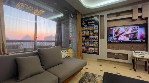a living room with a couch and a tv at Key of pyramids view inn in Cairo