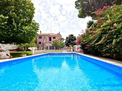 a large blue swimming pool in front of a house at FLH Yucca House Carcavelos Beach in Carcavelos