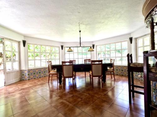a dining room with a table and chairs and windows at FLH Yucca House Carcavelos Beach in Carcavelos