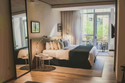 ein Schlafzimmer mit einem großen Bett und einem großen Fenster in der Unterkunft Anselmo Buenos Aires, Curio Collection by Hilton in Buenos Aires