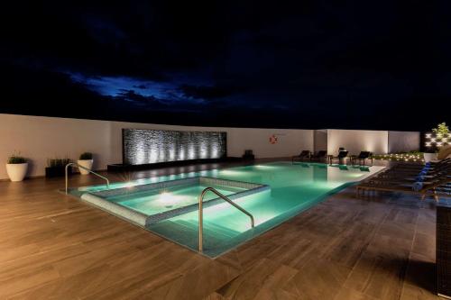 a swimming pool in a building with a dark ceiling at Hilton Garden Inn Salamanca in Salamanca