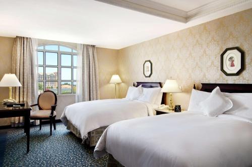 a hotel room with two beds and a window at Hilton Princess Managua in Managua