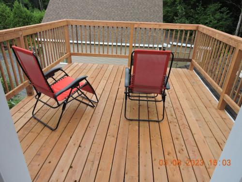 two chairs sitting on a wooden deck at Gite Passion et Tendresse B&B in Shefford