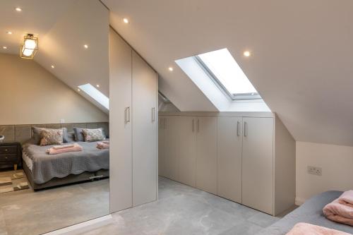 sypialnia na poddaszu z łóżkiem i oknem dachowym w obiekcie Beautiful 2-Bed Apartment in London w Londynie