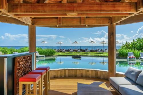 a patio with a pool with a couch and a table at Koi Resort Saint Kitts, Curio Collection by Hilton in Basse Terre Town