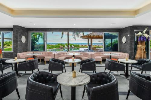 a restaurant with tables and chairs and windows at Koi Resort Saint Kitts, Curio Collection by Hilton in Basse Terre Town