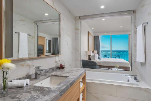 a bathroom with two sinks and a large mirror at Koi Resort Saint Kitts, Curio Collection by Hilton in Basse Terre Town