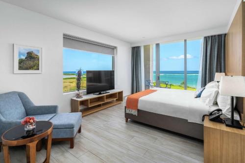 a hotel room with a bed and a large window at Koi Resort Saint Kitts, Curio Collection by Hilton in Basse Terre Town
