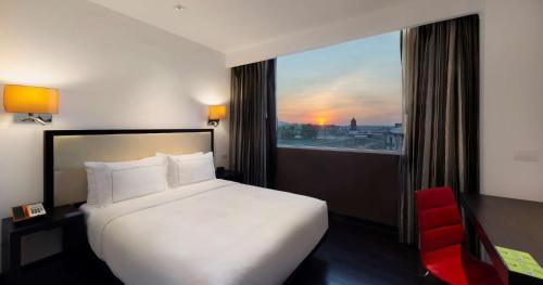 a hotel room with a bed and a window at Hilton DoubleTree Guadalajara Centro Historico in Guadalajara