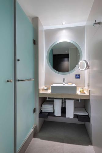 a bathroom with a sink and a mirror at Hilton DoubleTree Guadalajara Centro Historico in Guadalajara