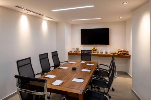 a conference room with a large wooden table and chairs at Hilton DoubleTree Guadalajara Centro Historico in Guadalajara