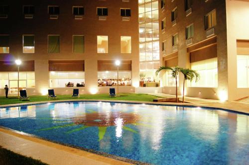 a large swimming pool in front of a building at Hilton Garden Inn Veracruz Boca del Rio in Veracruz