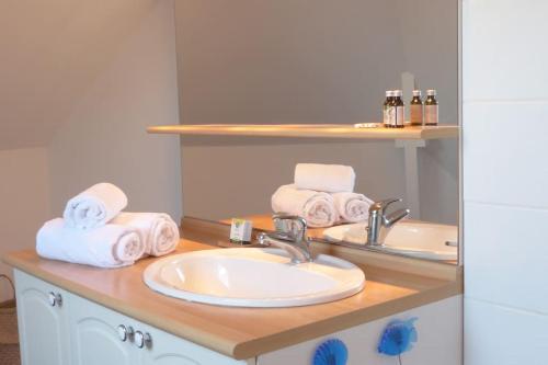 a bathroom with a sink and towels on a counter at Ty Kerigan, Maison 3* proche de la plage - Locmariaquer in Locmariaquer