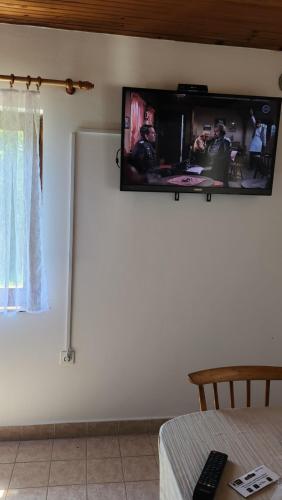 uma televisão de ecrã plano numa parede num quarto em Kuća djeda Ive 