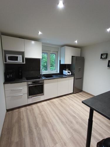 Il comprend une cuisine équipée d'appareils en acier inoxydable et du parquet. dans l'établissement Maison de ville avec terrasse, à Épinal