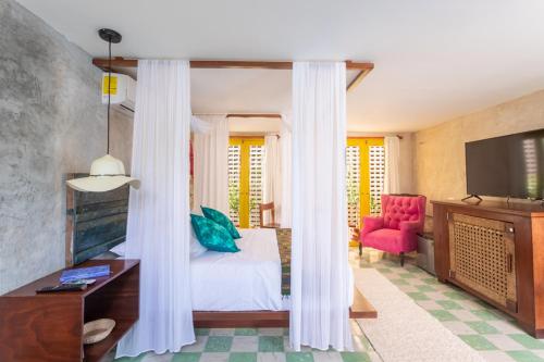 a hotel room with a bed and a tv at CASA CHAKÁ BOUTIQUE in Mérida