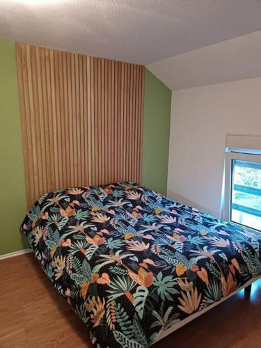 - une chambre avec un lit et une couverture colorée dans l'établissement Maison de ville avec terrasse, à Épinal