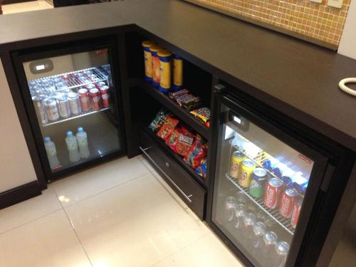 a counter with two refrigerators with drinks and soda at Hampton Inn Tampico Airport in Tampico