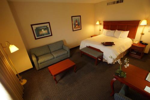 a hotel room with a bed and a chair at Hampton Inn Tampico Airport in Tampico