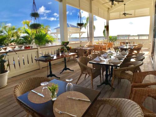 a restaurant with tables and chairs on a deck at Mahogany Bay Resort and Beach Club, Curio Collection in San Pedro