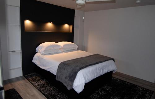 een slaapkamer met een bed met witte lakens en kussens bij Silva Domus in West Orange