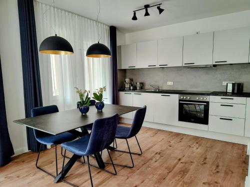 a kitchen with a table with blue chairs and appliances at Ferienwohnungen am Wasserfall in Bad Urach