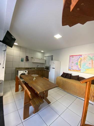 cocina con mesa de madera y sofá en Casa de Hóspedes com Piscina em Porto Belo, en Porto Belo