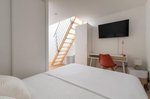 1 dormitorio con 1 cama y escritorio con TV en sousplex Cosy - proche tram et Corum - CLIM en Montpellier