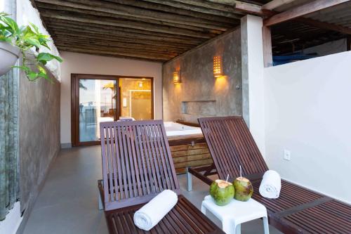 two chairs and a table with coconuts on a porch at Pousada Bahia Bacana in Morro de São Paulo