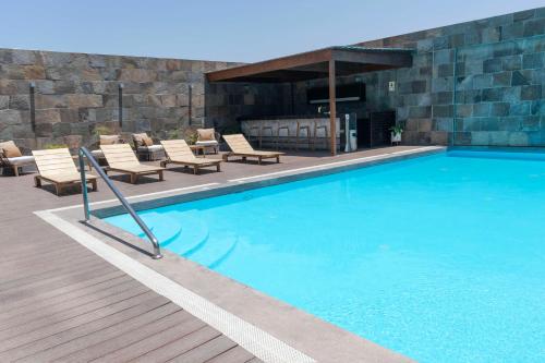 een groot zwembad met stoelen en een open haard bij Doubletree By Hilton Trujillo in Trujillo
