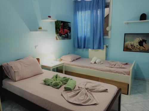 two beds in a room with blue walls at Vacation Apartment near the Sea in Kalives Poligirou